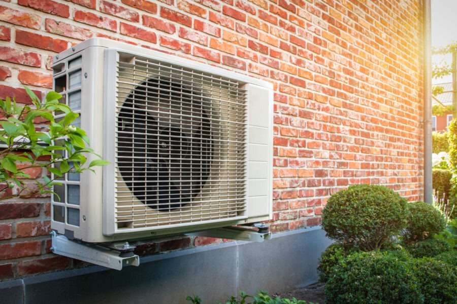 Air conditioning heat pump outdoor unit against brick wall